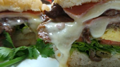 a close up of a sandwich with cheese and lettuce at Petit Rivera Hotel in Rivera
