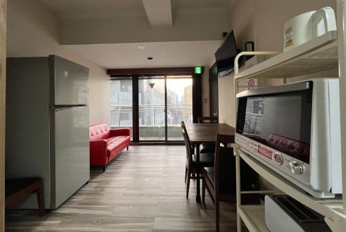 a kitchen and living room with a couch and a table at Le Tour Hotel Akihabara Kanda 楽途ホテル神田秋葉原 in Tokyo