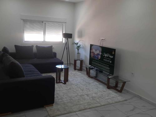 a living room with a couch and a flat screen tv at Résidence amira 5 in Oran