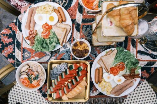 una mesa cubierta con platos de comida, huevos y carne en Cliffver คลิฟฟ์เวอร์, en Chiang Mai