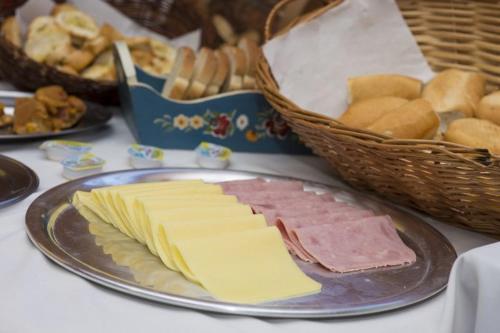a plate of cheese and bread and a basket of bread at Central Park Hotel São Carlos - Fácil Acesso USP e Industrial in São Carlos