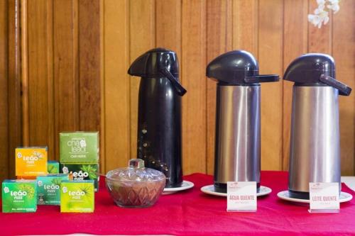a table with two coffee makers on a red table at Central Park Hotel São Carlos - Fácil Acesso USP e Industrial in São Carlos