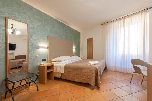 a hotel room with a bed and a mirror at Hotel Sole in Assisi