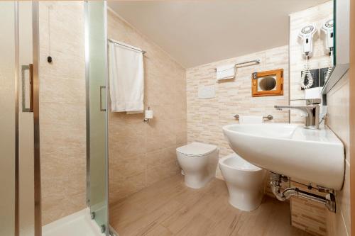 a bathroom with a sink and a toilet and a shower at Hotel Sole in Assisi