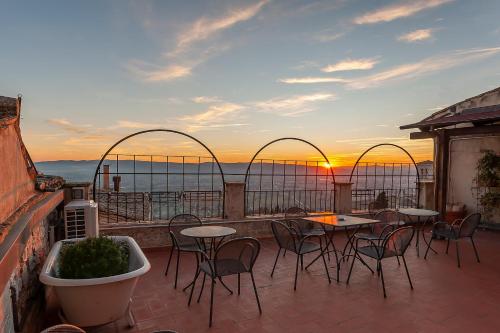 a patio with tables and chairs and a sunset at Hotel Sole in Assisi