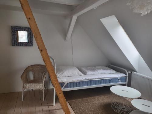 Cama en un ático con mesa y silla en Ferienwohnung Jeannette II, en Hasselfelde