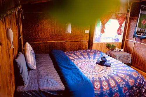 a bedroom with a bed with a blue comforter at La Beauté Bắc Hà in Bắc Hà