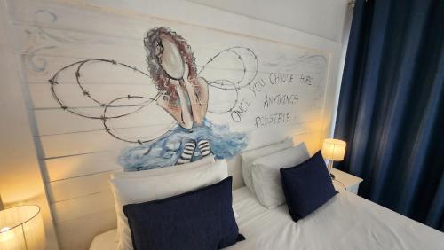 a bedroom with a bed with a painting on the wall at Be Our Guest Self Catering in Nelspruit