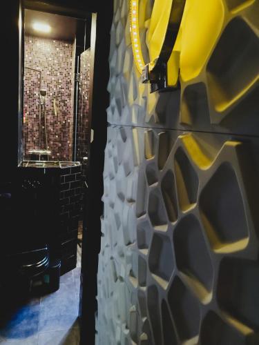 a bathroom with a wall covered in yellow and white tiles at Bel appartement à Clichy sur Seine in Clichy