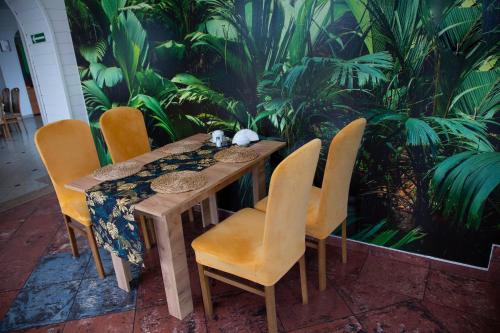 a wooden table with chairs and a plant wall at Motel Paradise in Torzym