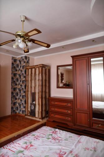 a bedroom with a ceiling fan and a dresser at Котедж у Карпатах in Tukholʼka
