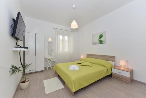 a bedroom with a green bed and a tv at Rooms Old Town in Zadar