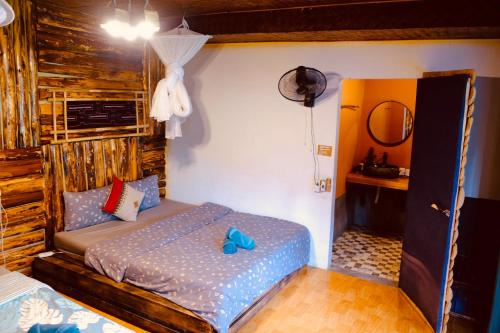 a bedroom with a bed with blue shoes on it at La Beauté Bắc Hà in Bắc Hà