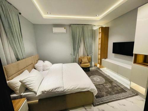 阿布賈的住宿－States Apartment，卧室配有白色的床和平面电视。