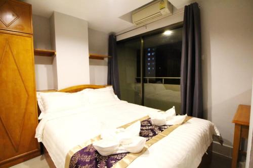 a hotel room with a bed with white towels on it at L Hotel in Bangkok