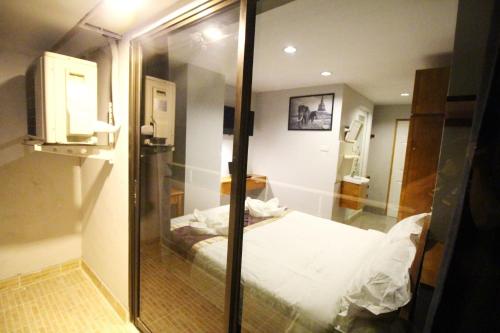 a room with a bed and a glass wall at L Hotel in Bangkok