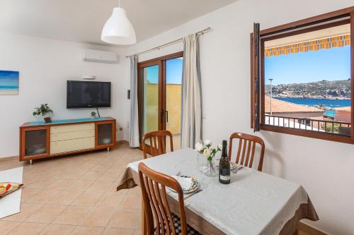 a dining room with a table and a view of the ocean at Fronte Mare Capo Testa in Santa Teresa Gallura