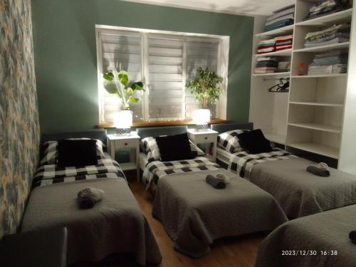 a room with four beds and a window at Apartament Centrum Nowa Ruda in Nowa Ruda