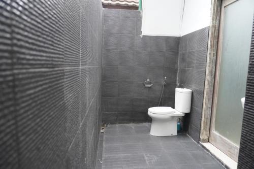 a bathroom with a white toilet in a stall at Rumah Tiga Gili in Gili Air