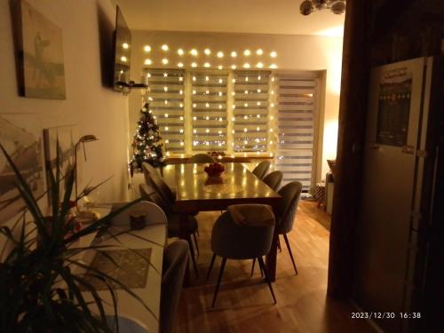 a dining room with a table and a christmas tree at Apartament Centrum Nowa Ruda in Nowa Ruda