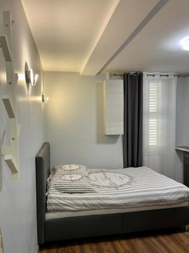 un lit dans une chambre avec une fenêtre dans l'établissement Charmant Studio au cœur historique de Fréjus, à Fréjus