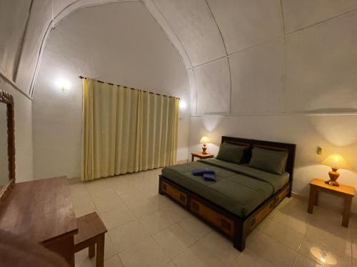 a bedroom with a bed with an arched ceiling at Rumah Tiga Gili in Gili Air