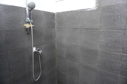 a bathroom with a shower with a shower head at Rumah Tiga Gili in Gili Air