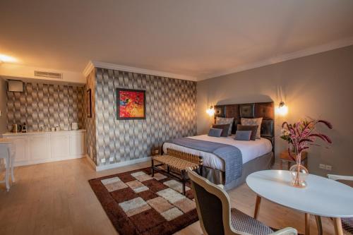 a hotel room with a bed and a table and chairs at LA VILLA in Terraube