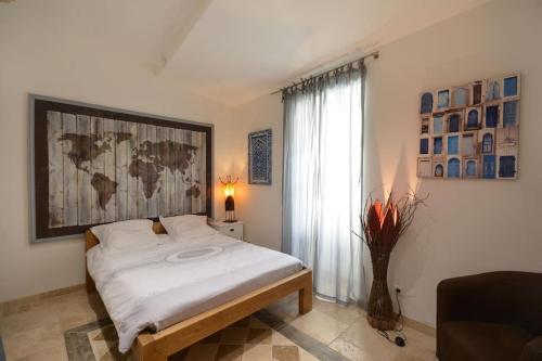 - une chambre avec un lit et une carte murale dans l'établissement Charmante petite maison donnant sur les Arènes, à Arles