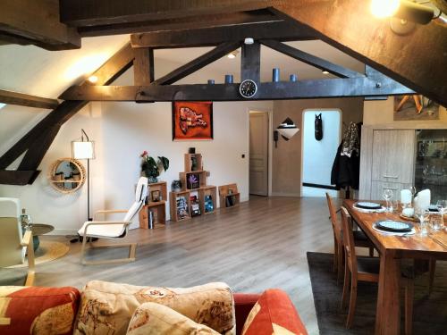 sala de estar con techos de madera, mesa y sillas en Chambre(s) dans loft partagé, cosy et spacieux! en Tarbes