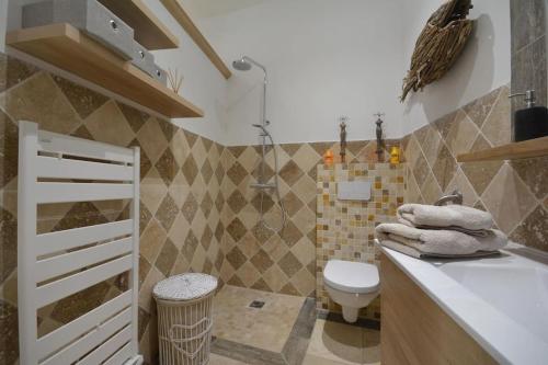 La salle de bains est pourvue d'un lavabo blanc et de toilettes. dans l'établissement Charmante petite maison donnant sur les Arènes, à Arles