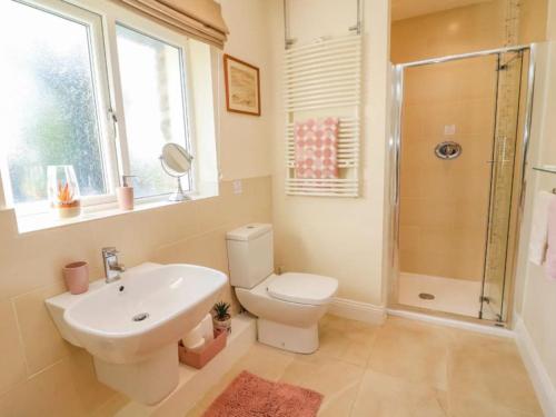 een badkamer met een toilet, een wastafel en een douche bij Two Acres- Spacious, delightful, pet free bungalow in Levens