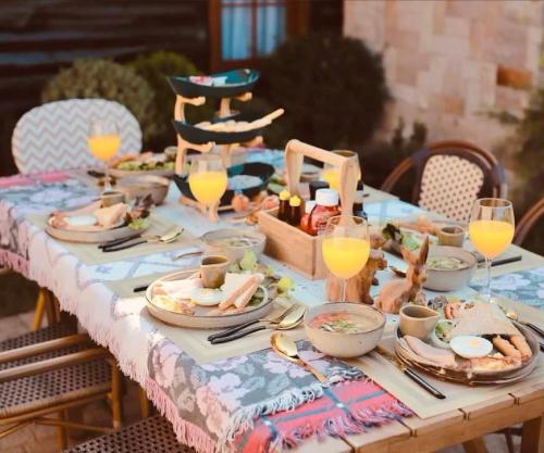 una mesa con platos de comida y vasos de zumo de naranja en Pine Village CNX, 