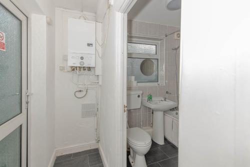 a bathroom with a toilet and a sink at Cosy 4 bedrooms house near Central London, O2, London city airport and Excel in Plumstead