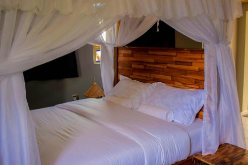 a bedroom with a white bed with a canopy at Amanya 3-Bedroom Hut Amboseli in Amboseli