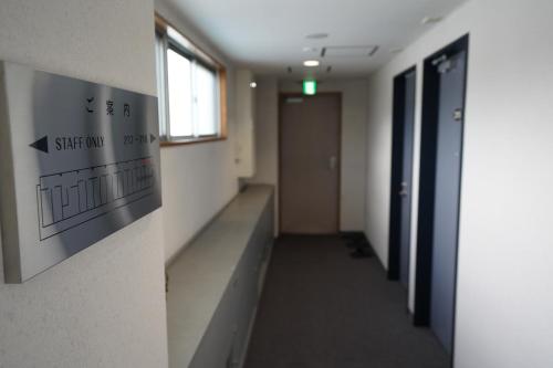 a hallway of an office with a sign on the wall at The Hakuba Station Room in Hakuba