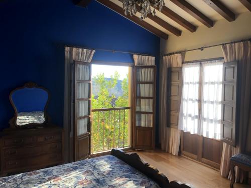 a bedroom with a bed and a large window at Casa Rural Trebol4Hojas in San Pedro