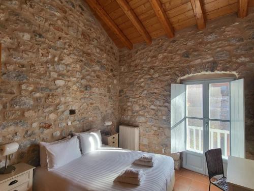 a bedroom with a bed in a stone wall at Balcony&Tower in Areopolis