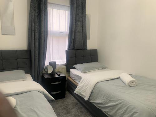 - une chambre avec 2 lits jumeaux et une fenêtre dans l'établissement L A PLACE Croydon, London, à Norwood