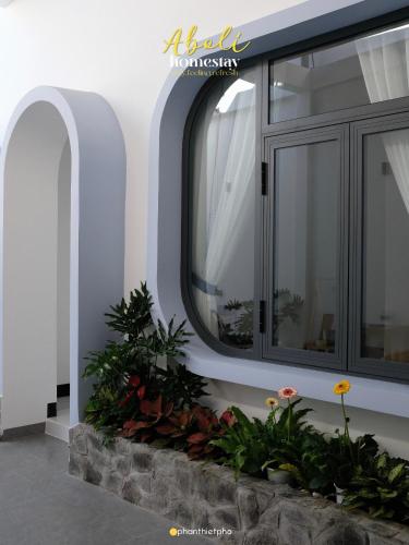 a window on a building with flowers in a planter at Aboli Homestay in Phan Thiet