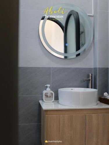 a bathroom with a sink and a mirror on the wall at Aboli Homestay in Phan Thiet