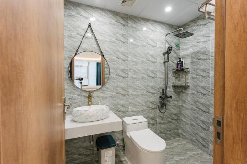 uma casa de banho com um WC, um lavatório e um espelho. em City view/ Central/ Big Bacony/2Br/1’ to lake em Hanói