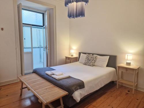 um quarto com uma cama com um banco e uma janela em Avenida Terrace em Lisboa