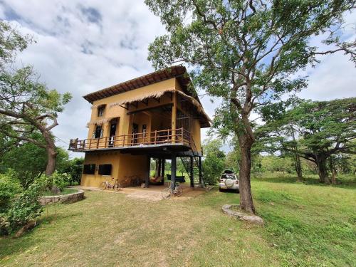 een huis met een balkon in een veld bij The Loft by the Lake in Kurunegala