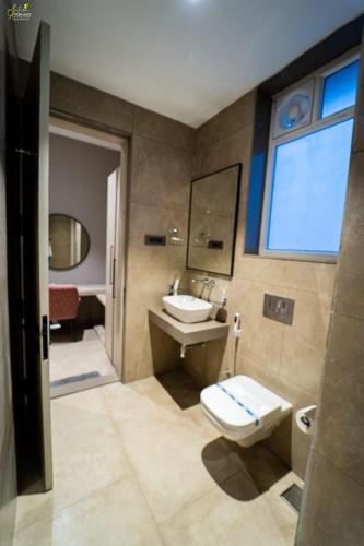 bagno con servizi igienici, lavandino e specchio di Hotel Grand Central Park a Nānded