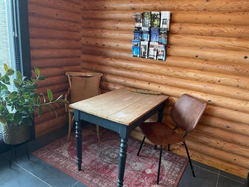 a wooden table and two chairs in front of a wall at BedandBreakfast Casa Martina in Kortgene