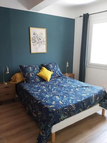 Ce lit se trouve dans une chambre dotée d'un mur bleu. dans l'établissement Superbe appartement au cœur du village, au Pradet