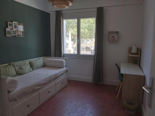 勒普拉代Superbe appartement au cœur du village的一间卧室配有一张带窗户的床和一张书桌