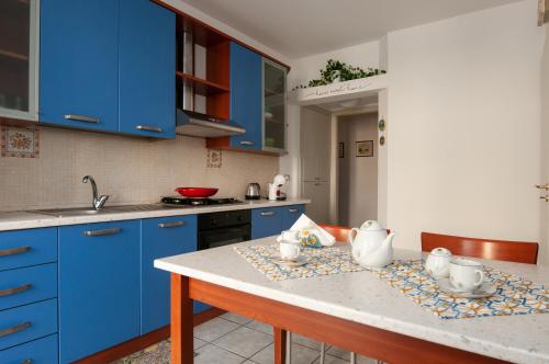 eine Küche mit blauen Schränken und einer Arbeitsplatte in der Unterkunft Lory's House - 400mt dal mare in Donnalucata