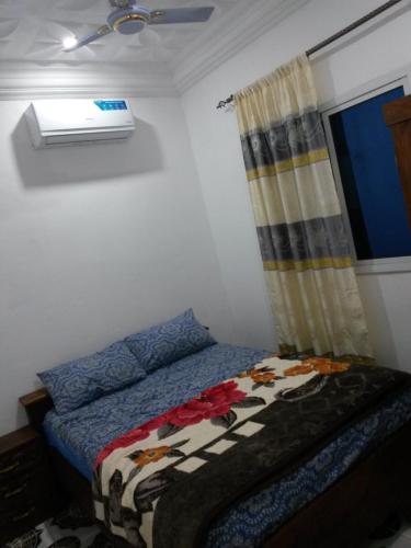 a bedroom with a bed and a window at LMD Apartments in Kololi